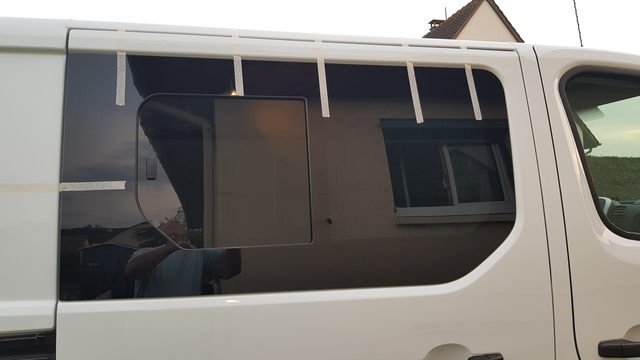 Porte latérale d'un Renault trafic L2H1 dont la partie haute a été découpée pour la mise en place d'une baie coulissante teintée.