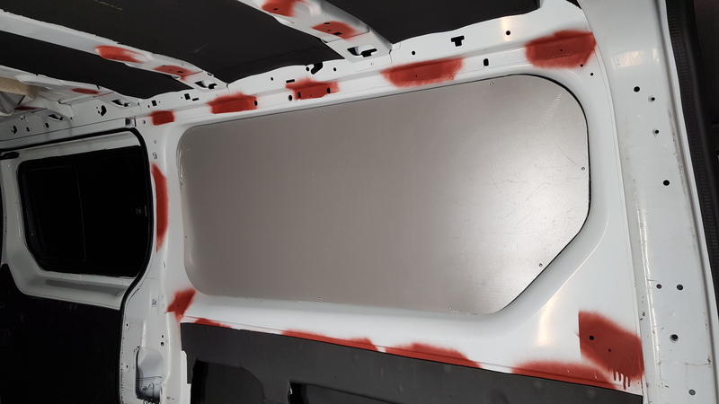 Intérieur d'un Renault trafic L2H1 en cours d'habillage d'une paroi latérale avec un panneau Pvc de la gamme Komatex. Le plafond est isolé avec de l'Armaflex.